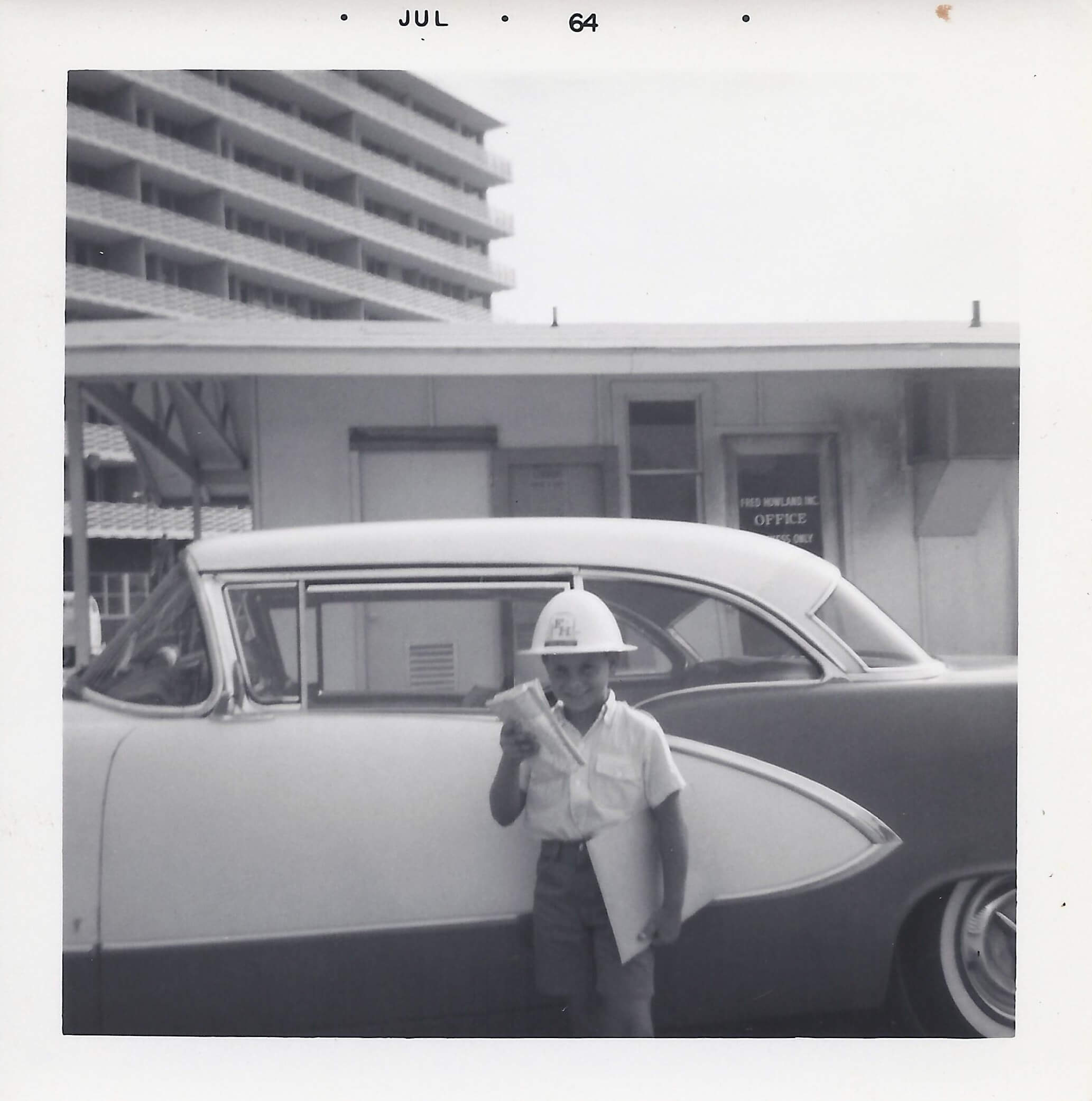 A man standing next to an old car.