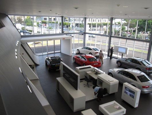 A car dealership with several cars in the showroom.