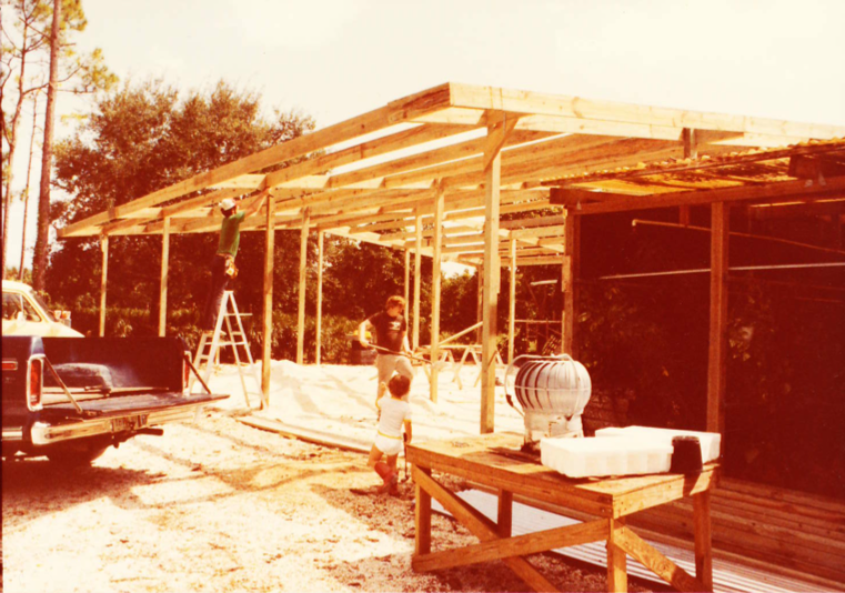 A construction worker is working on the roof of a building.