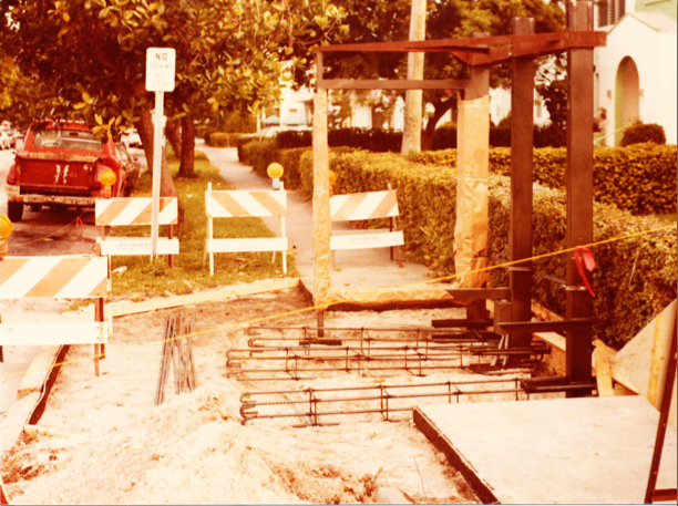 A construction site with trees and benches in the background.