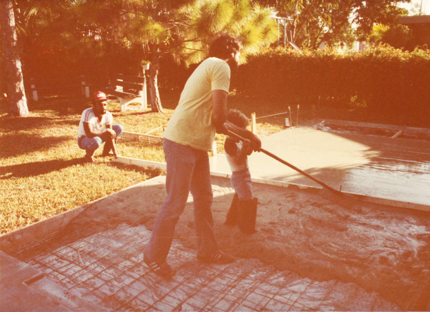 A man is sweeping the ground with an electric broom.