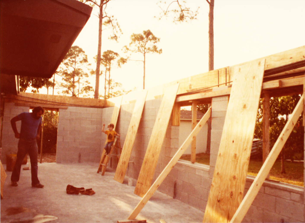 A person standing in front of some wood.